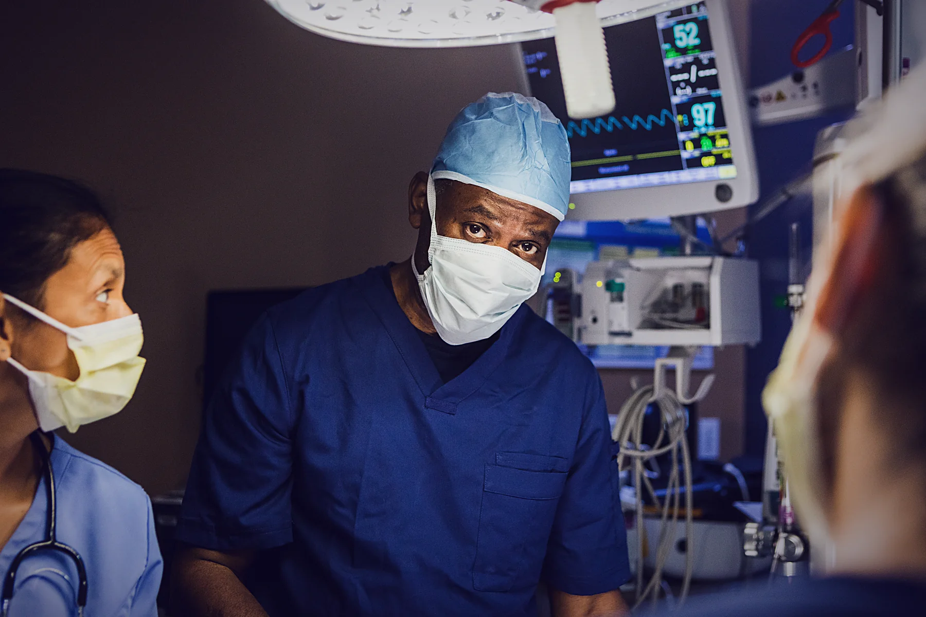 A clinical specialist in scrubs supporting a surgical team in theatre